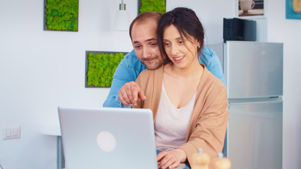 Cheerful couple using laptop with Pike Living